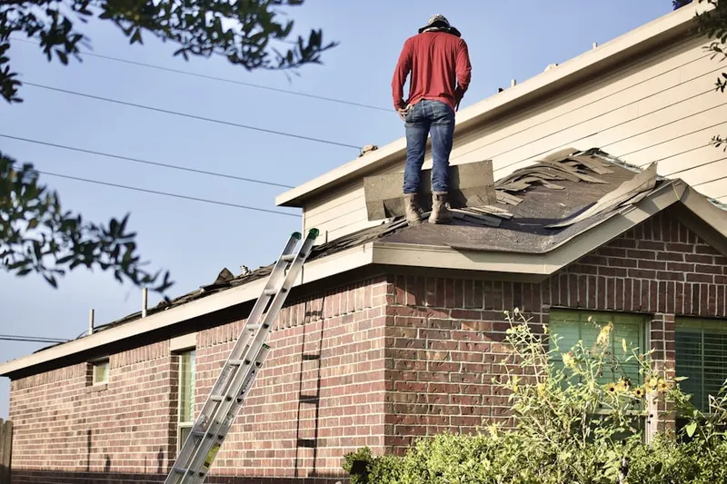 Professional roofer working on a residential roof in Land of Pines